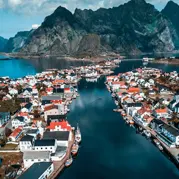 Mountainous island surrounded by city and boats