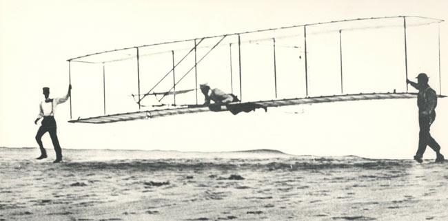 Man flying on early glider