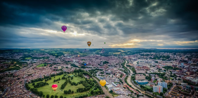 Hot air balloons flying over a city