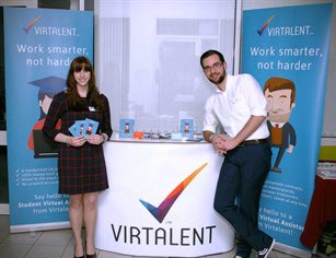 Two people standing at a promotional stand