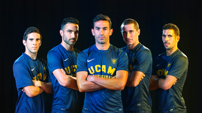 Five men dressed in university football team clothing
