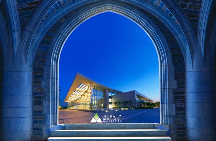 Futuristic campus building viewed at night through a window frame