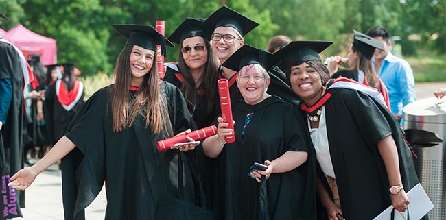 Graduating students smiling in student caps