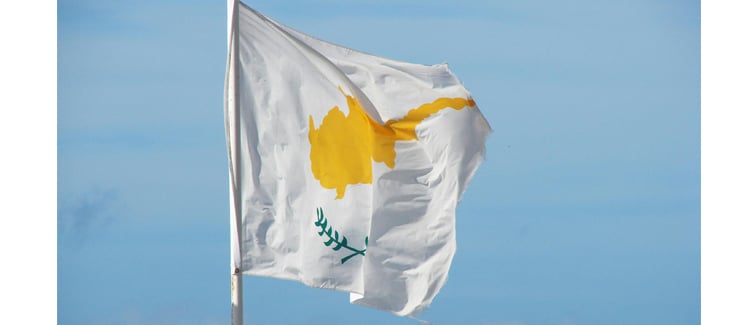Image of a white and yellow Cyprus flag on a flagpole
