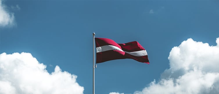 Image of a red and white Latvian flag on a flagpole