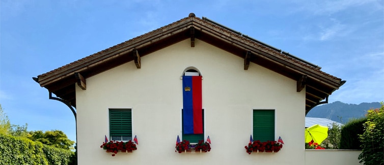 Image of a red and blue Liechtenstein flag hanging from a house
