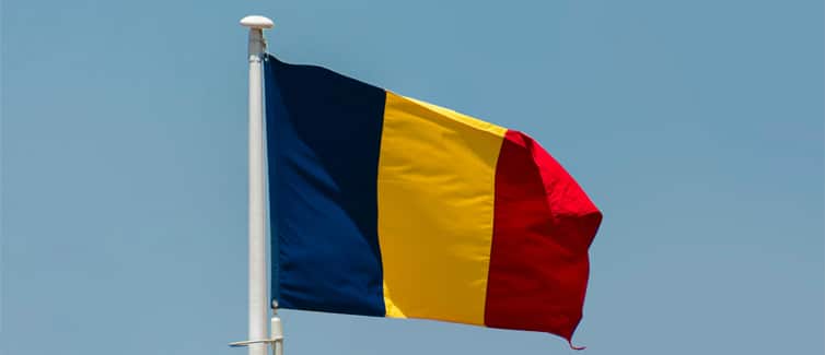 Image of a blue, yellow and red Romanian flag on a flagpole