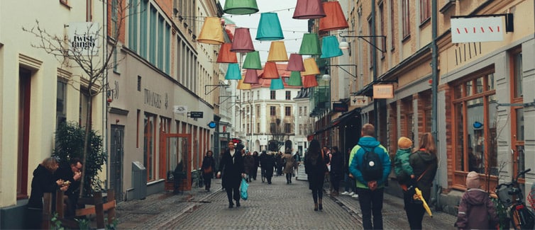 Image of people walking down a street, with lanterns hanging above people's heads