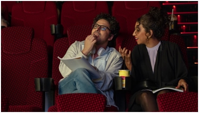 Image of two people sat in red cinema seats