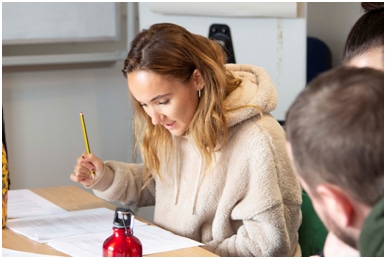 Small image of a student looking down at their work on a table