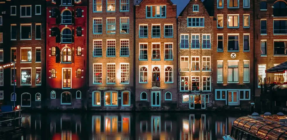 Townhouses at night reflected in the water of a canal