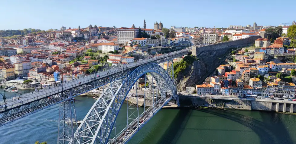 A large metal road bridge joining two sides of a city over a river