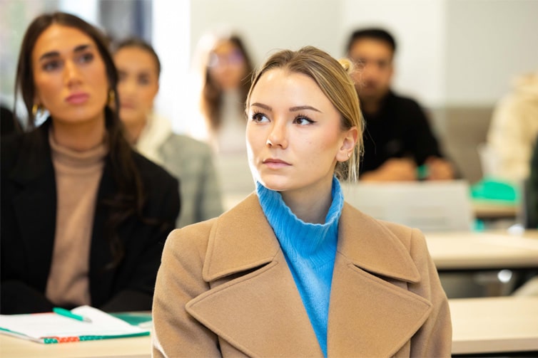 students sat at desks looking away from the camera