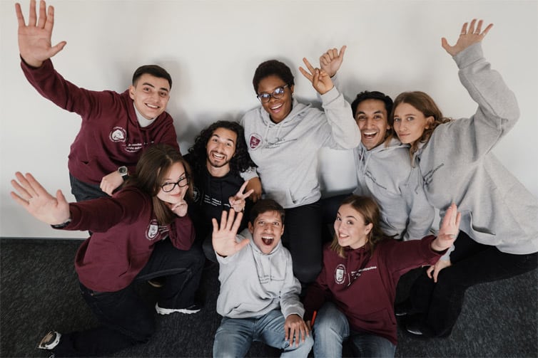 Eight students looking towards the camera and smiling