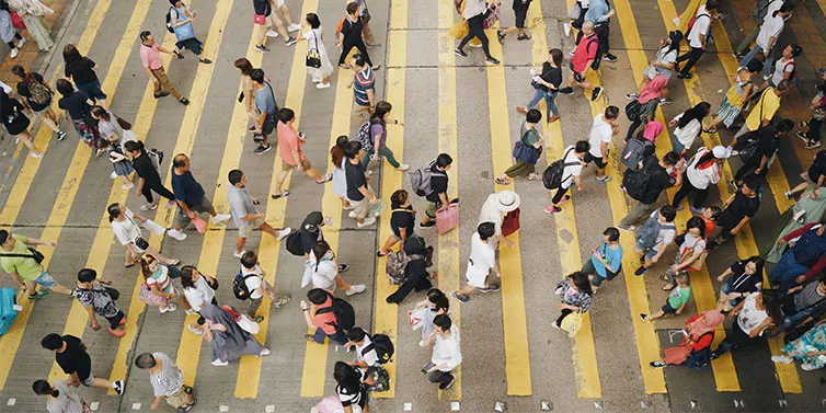 Crowds of people crossing busy street